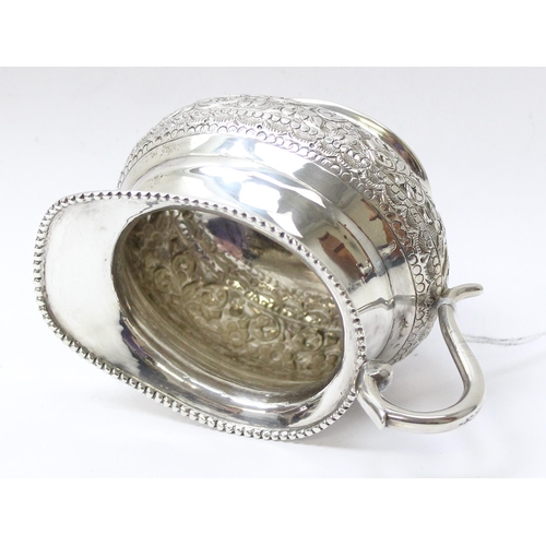 1035 - A large embossed silver cream or milk jug, likely Anglo-Indian, marked St Silver to the base and XRF... 