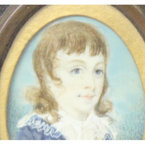 406 - A small antique portrait miniature of a young boy in Regency period dress, seemingly unsigned, in an... 