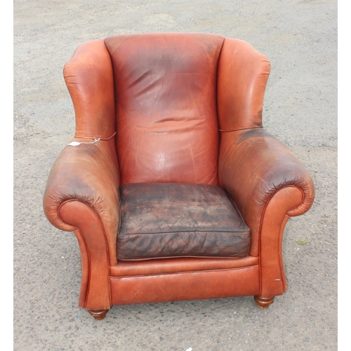 85 - A vintage brown leather club chair with turned wooden feet, approx 100cm wide