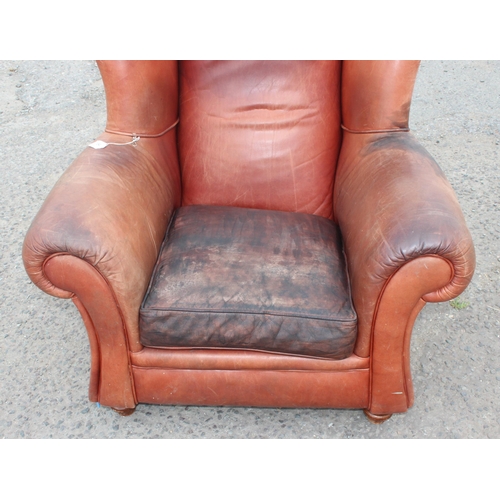 85 - A vintage brown leather club chair with turned wooden feet, approx 100cm wide