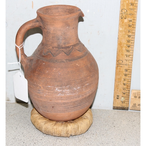 1668 - A pair of Bahrainian pottery jugs, made by prisoners, with rounded bottoms and wicker rings for stan... 