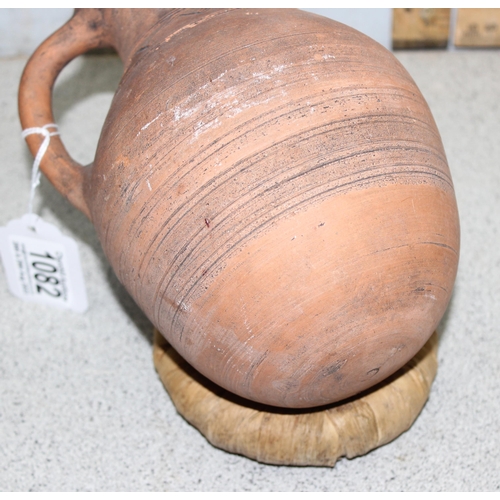 1668 - A pair of Bahrainian pottery jugs, made by prisoners, with rounded bottoms and wicker rings for stan... 