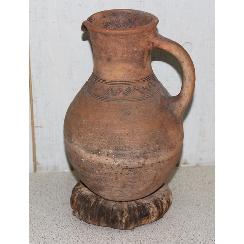 1668 - A pair of Bahrainian pottery jugs, made by prisoners, with rounded bottoms and wicker rings for stan... 