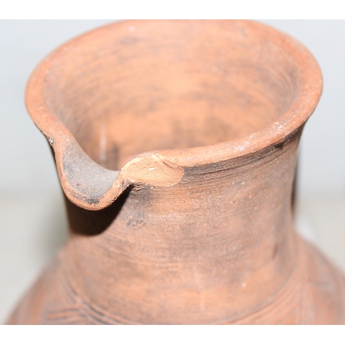 1668 - A pair of Bahrainian pottery jugs, made by prisoners, with rounded bottoms and wicker rings for stan... 