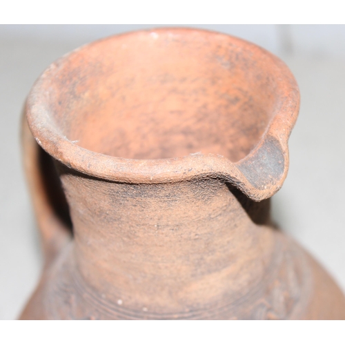 1668 - A pair of Bahrainian pottery jugs, made by prisoners, with rounded bottoms and wicker rings for stan... 