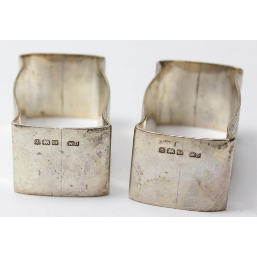 1046 - A heavy pair of silver napkin rings of cushion form, with engine turned design, Birmingham 1928 by W... 