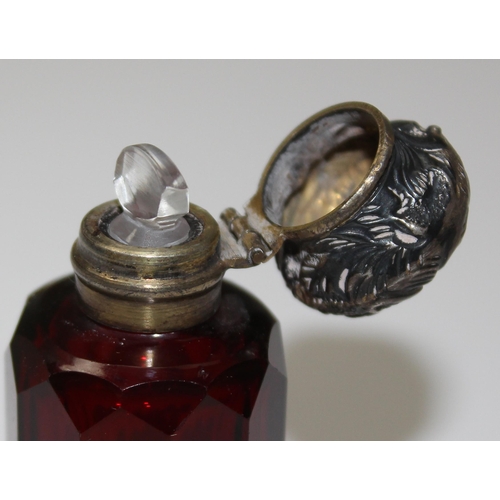 1072 - Victorian ruby glass scent bottle with a gilded top and complete with glass stopper, top seemingly u... 