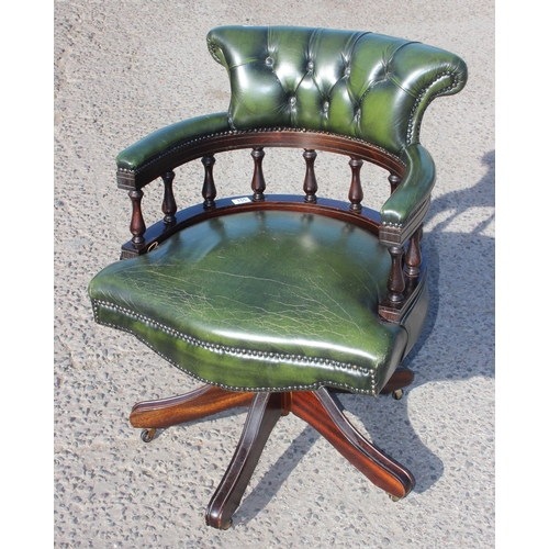 155 - A green leather captain's style desk chair with chesterfield button back