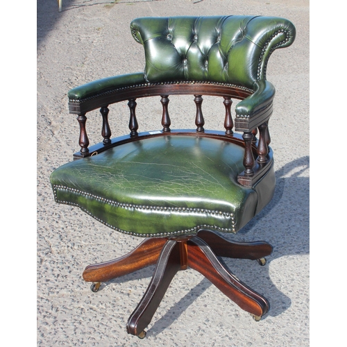 155 - A green leather captain's style desk chair with chesterfield button back