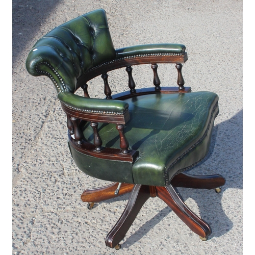 155 - A green leather captain's style desk chair with chesterfield button back