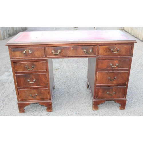 159 - A red leather topped and mahogany effect 3 part pedestal desk, approx 121cm wide x 61cm deep x 67cm ... 