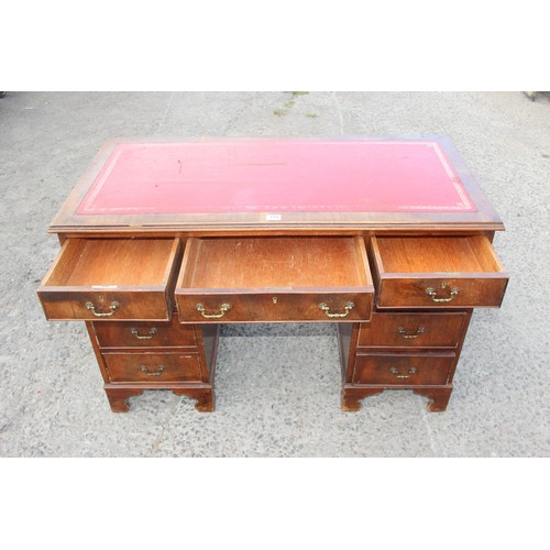 159 - A red leather topped and mahogany effect 3 part pedestal desk, approx 121cm wide x 61cm deep x 67cm ... 