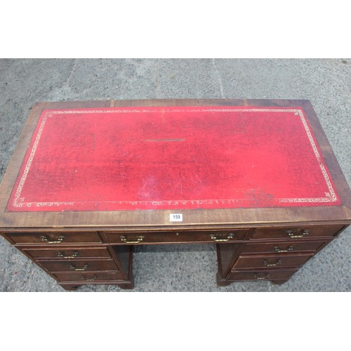 159 - A red leather topped and mahogany effect 3 part pedestal desk, approx 121cm wide x 61cm deep x 67cm ... 