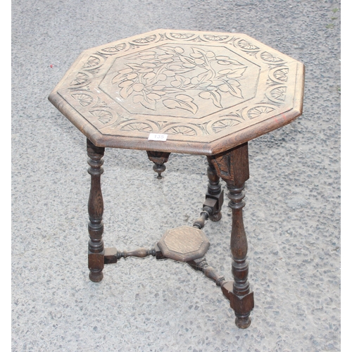 135 - An Arts & Crafts period carved oak octagonal table, the top carved with leaves and decorative demi-l... 