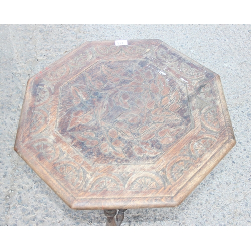 135 - An Arts & Crafts period carved oak octagonal table, the top carved with leaves and decorative demi-l... 