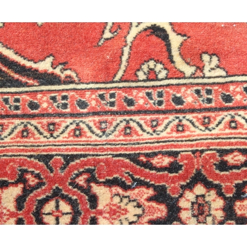 212 - Vintage red ground rug with central black medallion, approx 135cm x 150cm