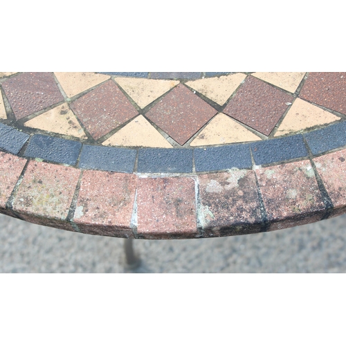 332 - Mosaic effect tile topped garden table with wrought iron base, approx 100cm in diameter x 75cm tall