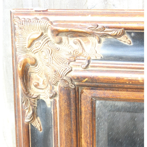 430 - Large wall mirror with black and gilt frame and bevelled glass, approx 116cm x 88cm