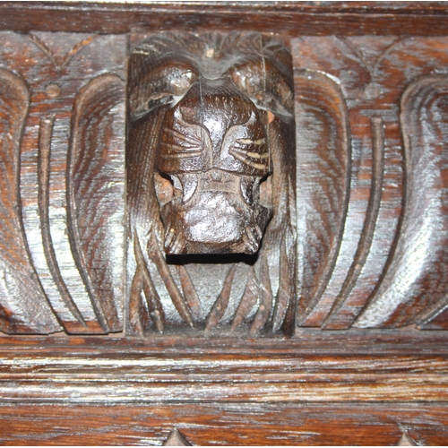 64 - An interesting highly decorative 17th century style carved oak bookcase cupboard with single drawer,... 