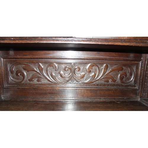 64 - An interesting highly decorative 17th century style carved oak bookcase cupboard with single drawer,... 