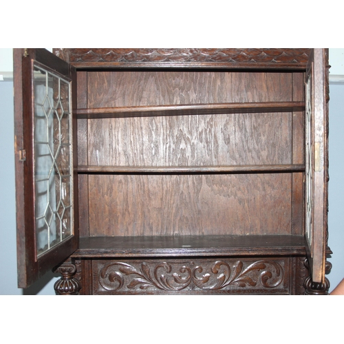 64 - An interesting highly decorative 17th century style carved oak bookcase cupboard with single drawer,... 