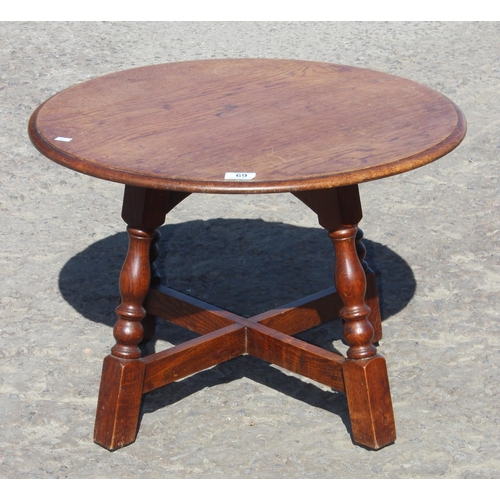 69 - A vintage round oak table with X stretcher, approx 60cm in diameter x 42cm tall