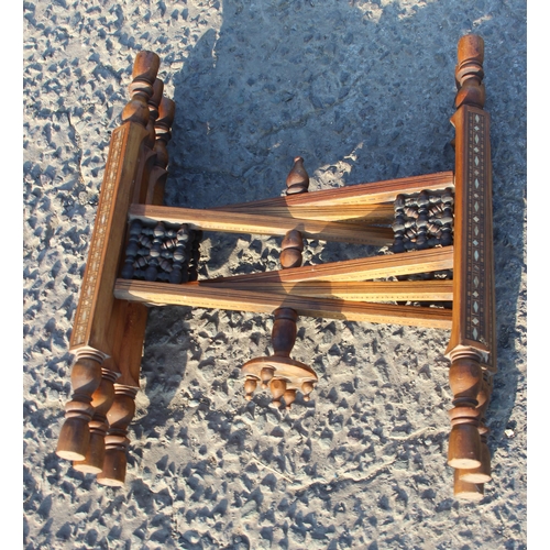 78 - A Benares brass topped tray table with folding wooden base, the top approx 56cm in diameter