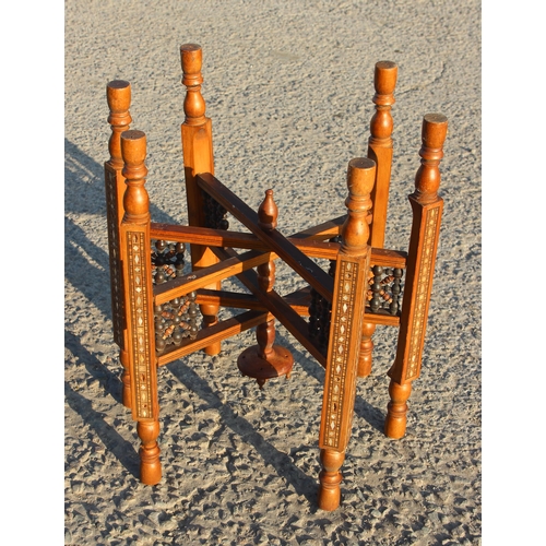 78 - A Benares brass topped tray table with folding wooden base, the top approx 56cm in diameter