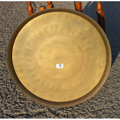 78 - A Benares brass topped tray table with folding wooden base, the top approx 56cm in diameter