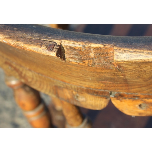 80 - A vintage oak or elm seated smokers bow or captain's armchair, likely early 20th century, approx 62c... 