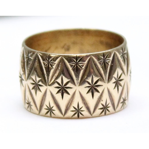 1135 - A 9ct gold retro band or stopper ring with facet cut and star decoration, marked for London 1976, ap... 