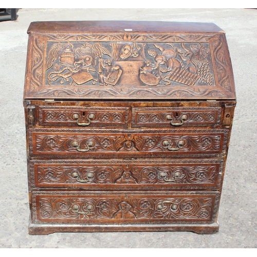 118 - An impressive profusely carved oak bureau, likely Georgian with later carving of a theatrical nature... 