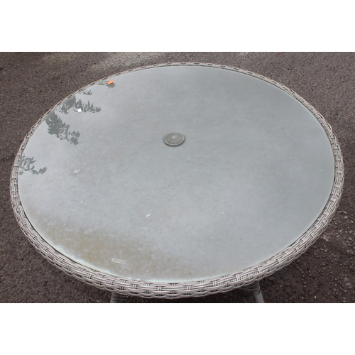 302A - A glass topped and rattan garden table, approx 101cm in diameter