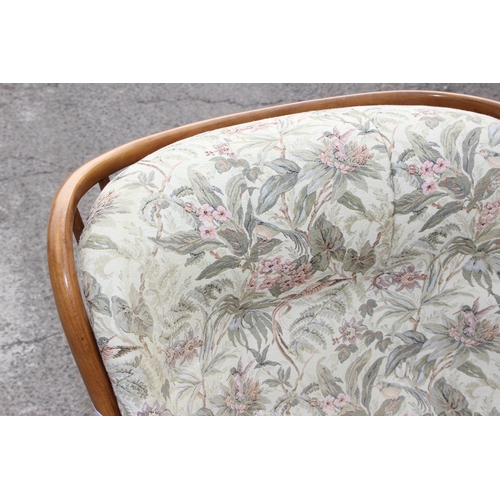 24 - A pair of retro his & hers Ercol armchairs with floral upholstered cushions