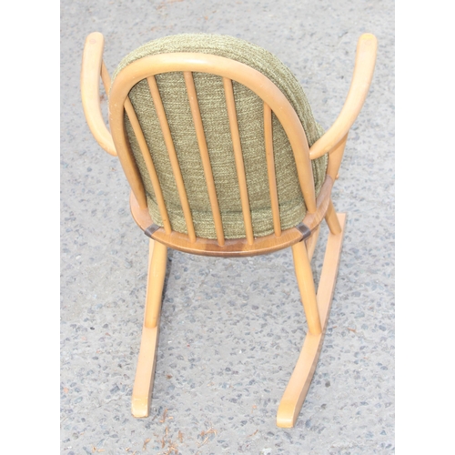 23 - A retro blonde Ercol hoop-back rocking chair with cushions