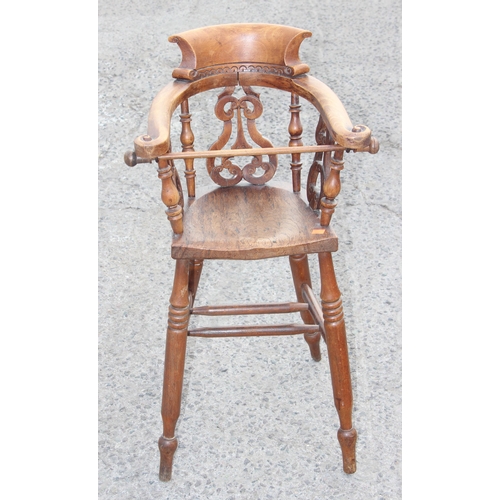 10 - Antique wooden smoker's-bow style baby's highchair with elm seat and carved details, approx height 8... 