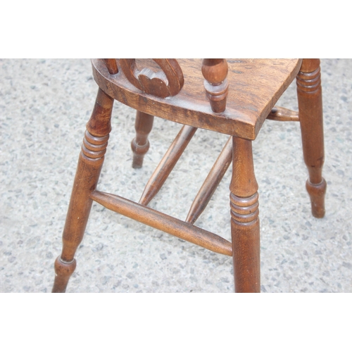 10 - Antique wooden smoker's-bow style baby's highchair with elm seat and carved details, approx height 8... 