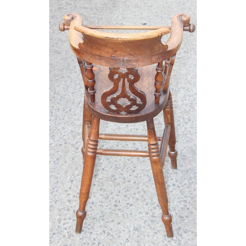 10 - Antique wooden smoker's-bow style baby's highchair with elm seat and carved details, approx height 8... 