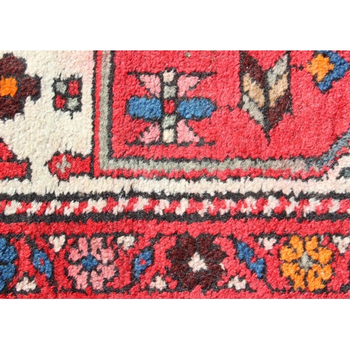 211 - A vintage red ground handmade rug with colourful decoration, possibly Hamadan region, approx 230cm x... 