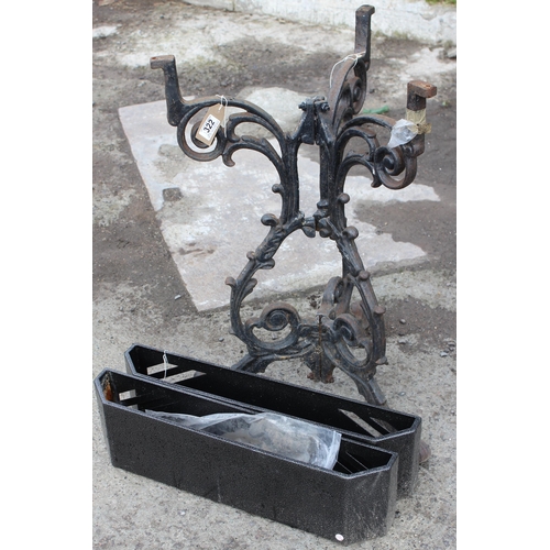 322 - A vintage cast iron garden table base and a pair of painted metal wall mounted planters