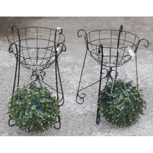 323 - A pair of wrought iron garden basket planters and faux bushes, each approx 58cm tall x 40cm wide