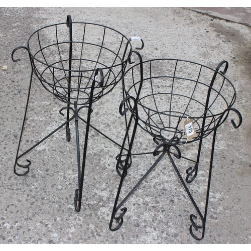 323 - A pair of wrought iron garden basket planters and faux bushes, each approx 58cm tall x 40cm wide