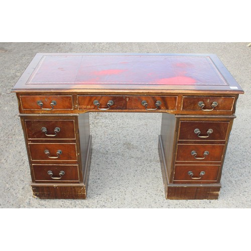 88 - A red leather topped and mahogany effect 3 part pedestal desk, approx 121cm wide x 61cm deep x 67cm ... 