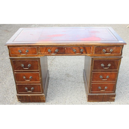 88 - A red leather topped and mahogany effect 3 part pedestal desk, approx 121cm wide x 61cm deep x 67cm ... 