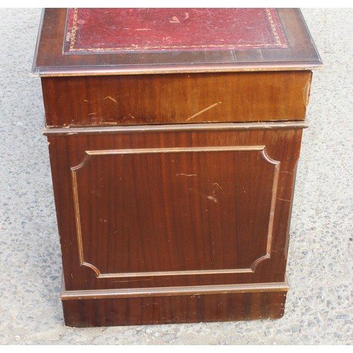 88 - A red leather topped and mahogany effect 3 part pedestal desk, approx 121cm wide x 61cm deep x 67cm ... 