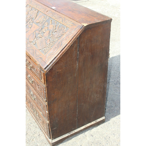 98 - An impressive profusely carved oak bureau, likely Georgian with later carving of a theatrical nature... 