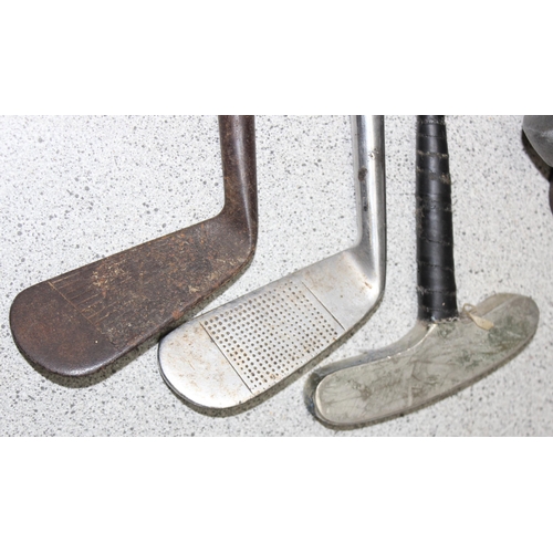 704 - Qty of vintage wooden handled and other golf clubs to include various irons and putters