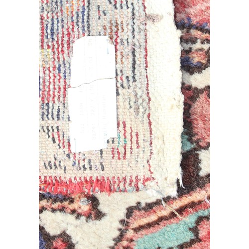 219A - Roll of colourful upholstery material, approx 150cm wide, and woollen hand tied red ground rug appro... 