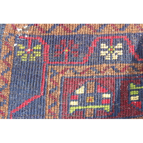 210 - A vintage red, blue and cream ground Turkish rug, approx 117cm x 55cm