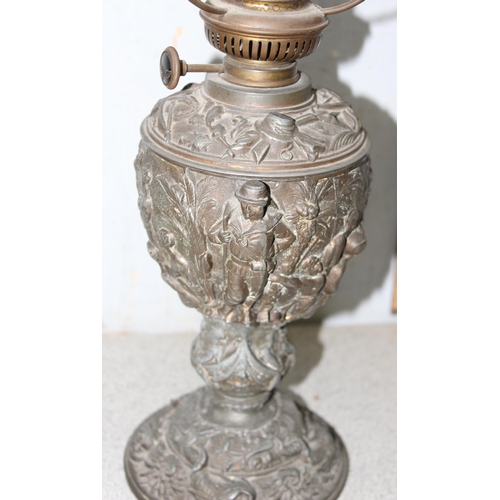 269A - An antique oil lamp, the base cast spelter depicting scenes of either missionaries or slave traders ... 